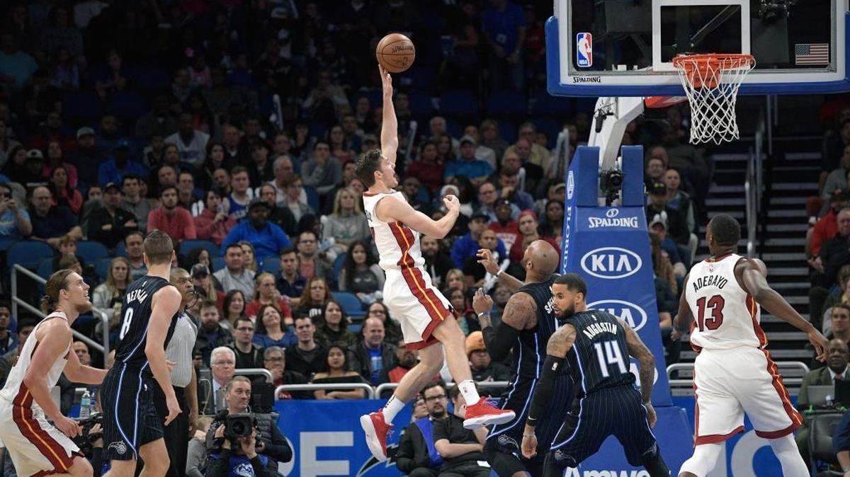 Kelly Olynyk (izq. y Bam Adebayo (der.) observan el disparo del armador del Heat Goran Dragic frente a los jugadores del Magic Marreese Speights (5) y D.J. Augustin (14) el 30 de diciembre en Orlando.