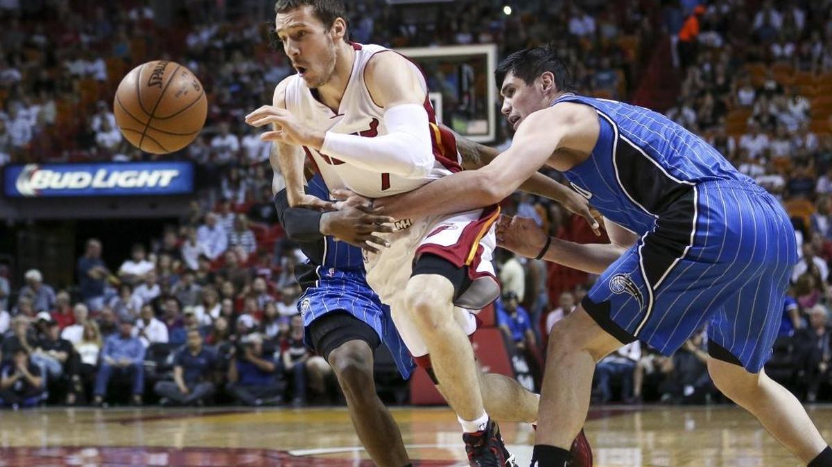 Goran Dragic, del Heat, esquiva dos rivales del Magic, la noche del domingo en Miami.