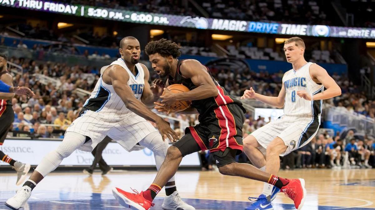 Serge Ibaka, del Magic (izq.), gardea a Justise Winslow, del Heat, en el partido inagural el 26 de octubre en Orlando.