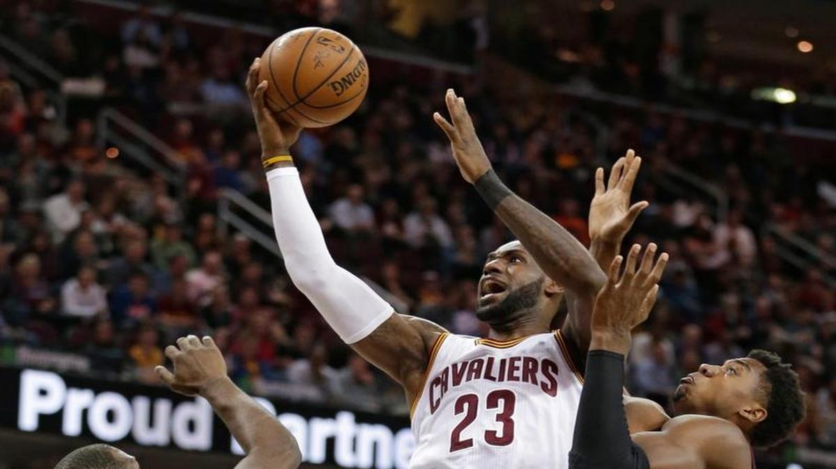 LeBron James, de los Cavaliers (23), entra al aro entre los jugadores del Heat Dion Waiters (11) y Hassan Whiteside, el 6 de marzo.