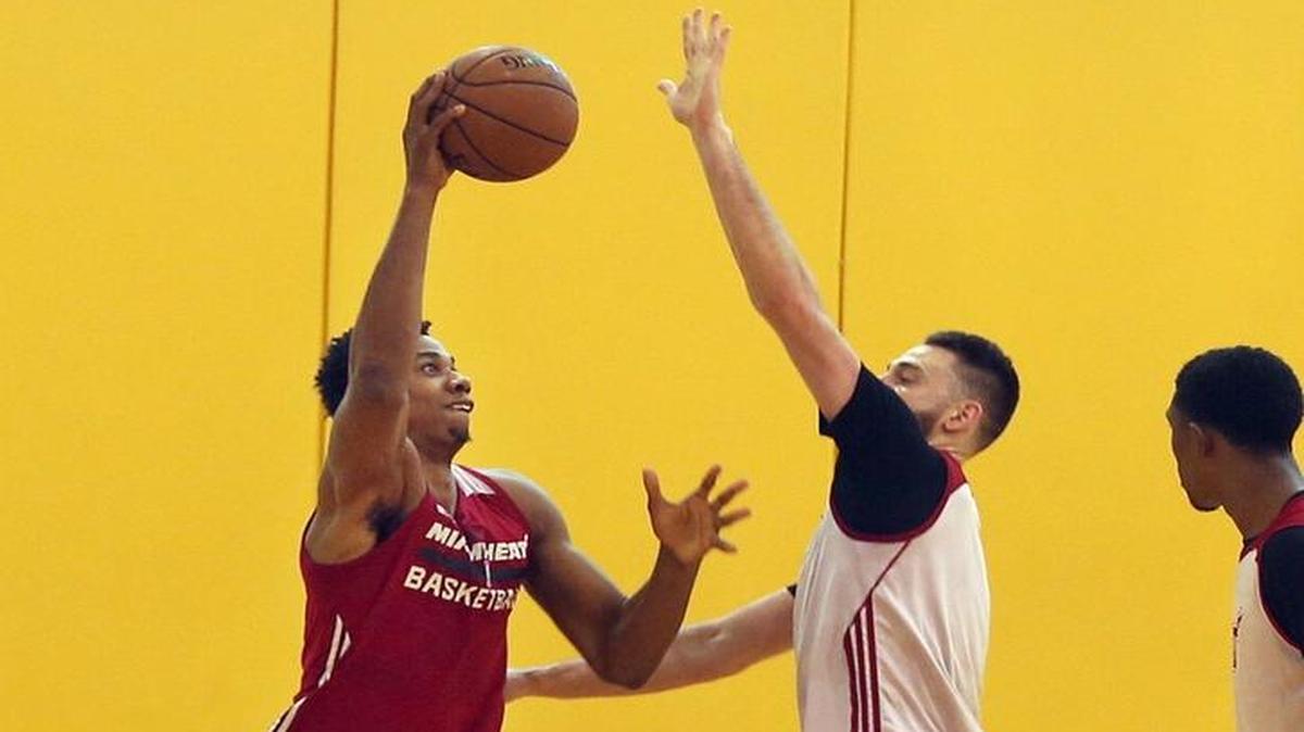 Hassan Whiteside (izq.) se enfrenta a Josh McRoberts durante la práctica del Heat, en el AmericanAirlines Arena en Miami, el viernes 15 de abril del 2016.