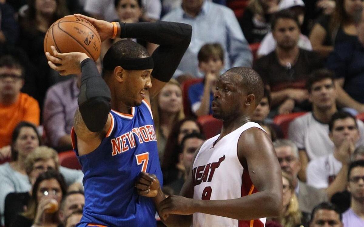 El jugador de los Knicks Carmelo Anthony (izq.) trata de pasar la pelota ante la marca de Luol Deng, del Heat, el miércoles 6 de enero del 2015 en Miami.