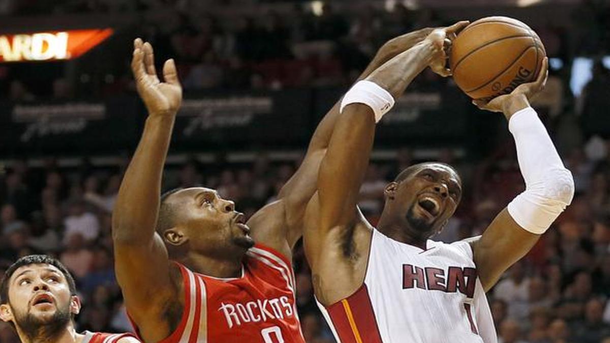 
El jugador del Heat Chris Bosh tira al aro y es bloqueado por Joey Dorsey, de los Rockets, el martes en Miami.


