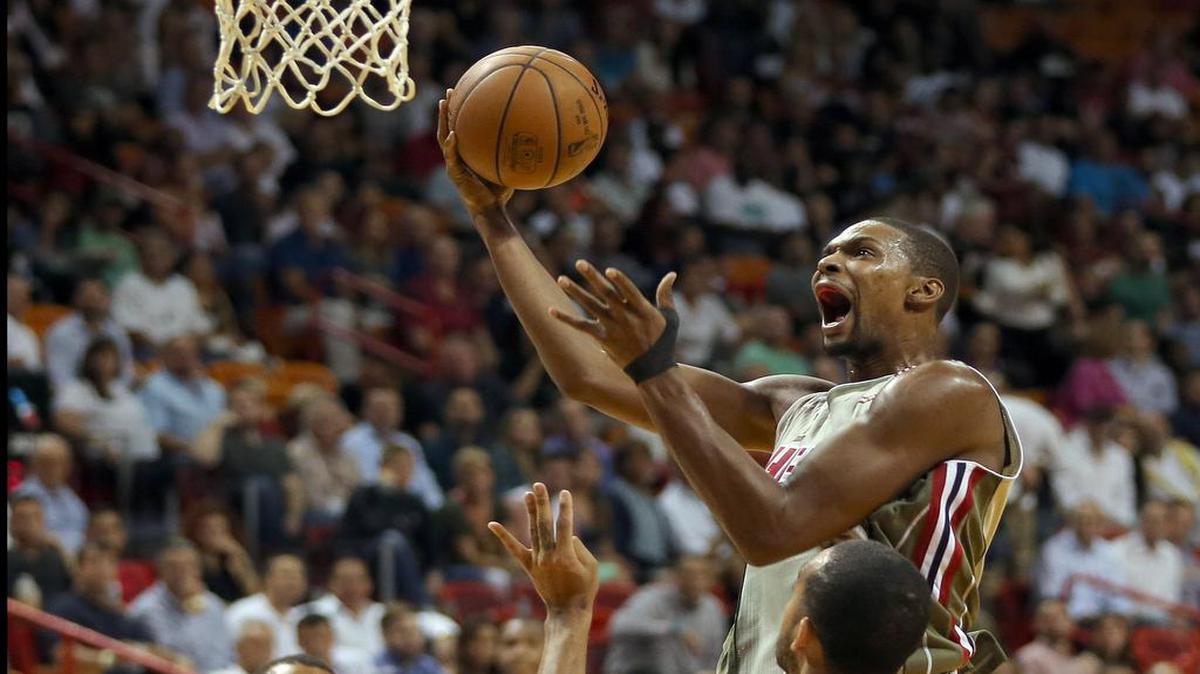 Chris Bosh penetra al aro por el Heat ante la marca del jugador de Utah Trey Lyles (# 41), en el primer cuarto del partido efectuado el jueves en Miami.