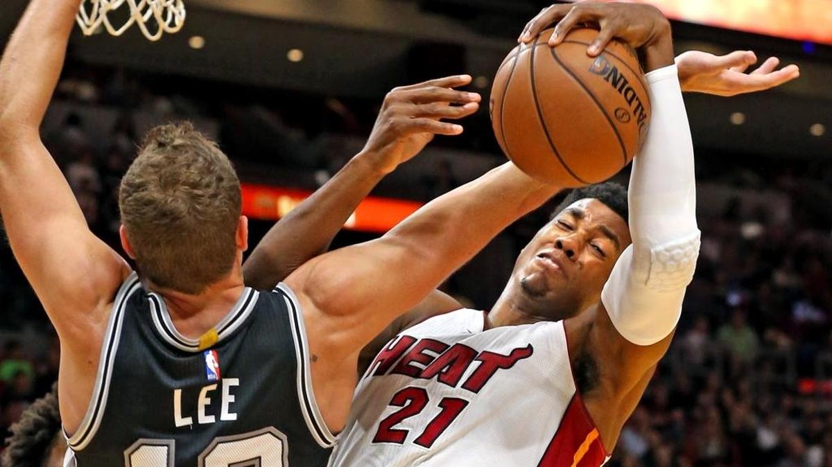 Hassan Whiteside (21), del Heat, lucha por el rebote con David Lee, de los Spurs, la noche del domingo en Miami.