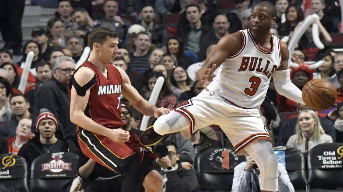 Dwyane Wade, de los Bulls (3), es marcado por Goran Dragic, del Heat (7). Ambos fueron los mejores de sus respectivos equipos en el triunfo de Miami este viernes en Chicago.