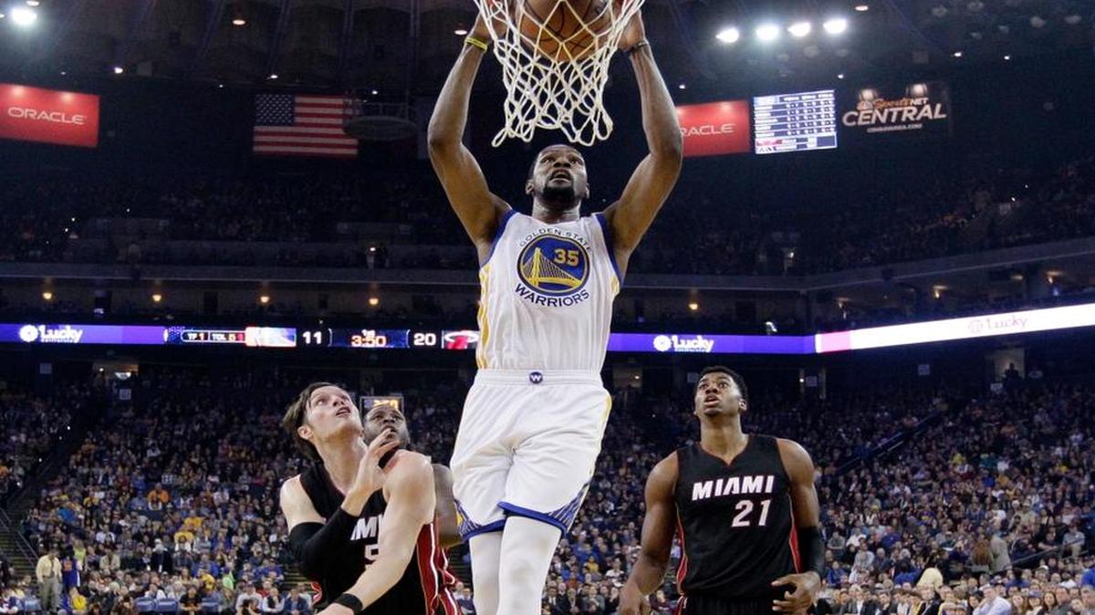 Kevin Durant (#35) clava la pelota por los Warriors ante la marca de Luke Babbitt (izq.) y Hassan Whiteside el martes 10 de enero del 2017 en Golden State.