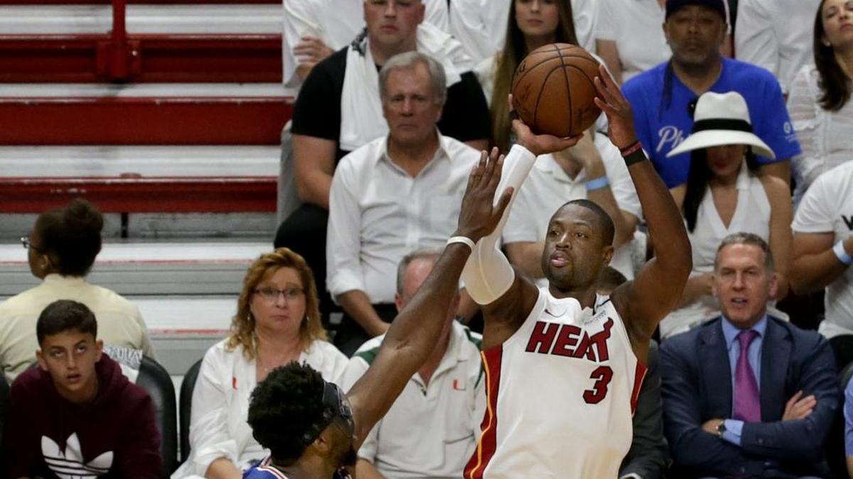 Dwyane Wade tira al aro ante la marca de Joel Embiid, de Filadelfia, en el primer cuarto del partido efectuado el sábado 21 de abril de 2018 en Miami.