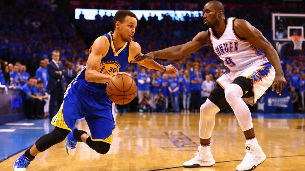 EL JUGADOR de los Warriors de Golden State, Stephen Curry (#30), busca penetrar al aro ante la presión de Serge Ibaka de los Thunders en el sexto partido de la serie final por el título de la Conferencia Oeste, el sábado en Oklahoma.