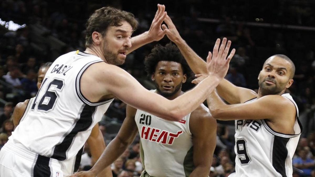 El español Pau Gasol (16) y el francés Tony Parker (9), de los Spurs, miran la bola junto con Justise Winslow (20), del Heat de Miami, la noche del lunes 14 de noviembre del 2016, en San Antonio.
