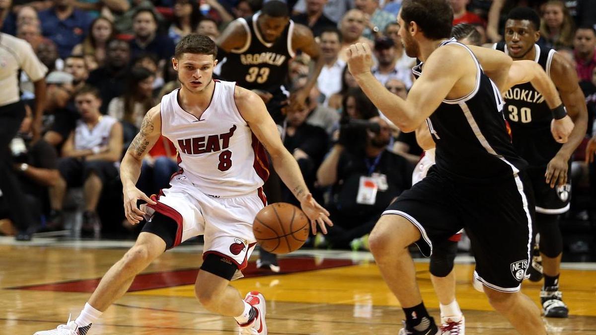 Tyler Johnson (izq.) conduce la pelota por el Heat ante la defensa de Bojan Bogdanovic, de los Nets de Brooklyn, en el último cuarto del partido del lunes en Miami.