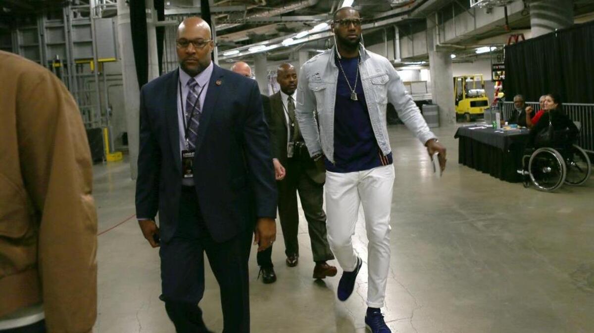 El astro de los Cavaliers LeBron James (der.) arriba al American Airlines Arena para enfrentar al Heat el 4 pasado de marzo.