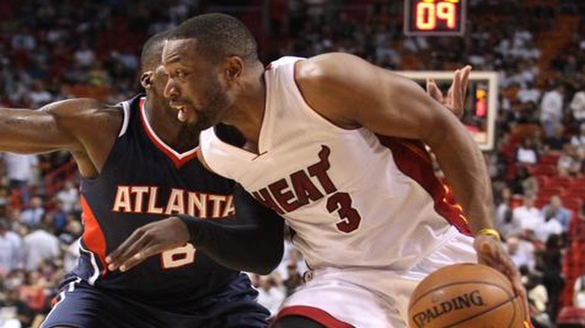 
El escolta del Heat Dwyane Wade trata de entrar al aro ante la marca del jugador de Atlanta Shelvin Mack, el miércoles en Miami.


