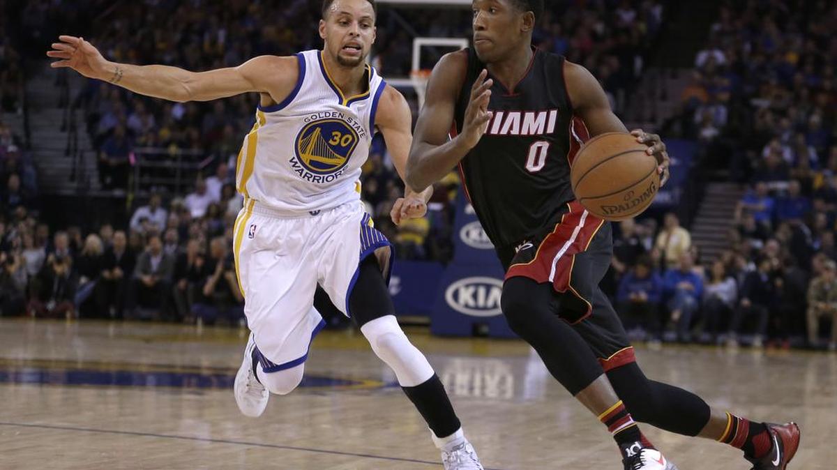 El jugador del Heat Josh Richardson (der.) trata de penetrar al aro ante la defensa de Stephen Curry, de los Warriors, en el partido efectuado el 11 de enero del 2015 en Oakland, California.