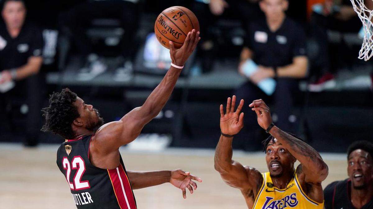 Jimmy Butler del Heat de Miami va hacia la canasta mientras lo defiende Dwight Howard de los Lakers de Los Ángeles el 30 de septiembre del 2020. El 1 de octubre del 2020 a pesar de las lesiones, el Heat no da por perdida la serie de Finales ante los Lakers. (AP Photo/Mark J. Terrill)