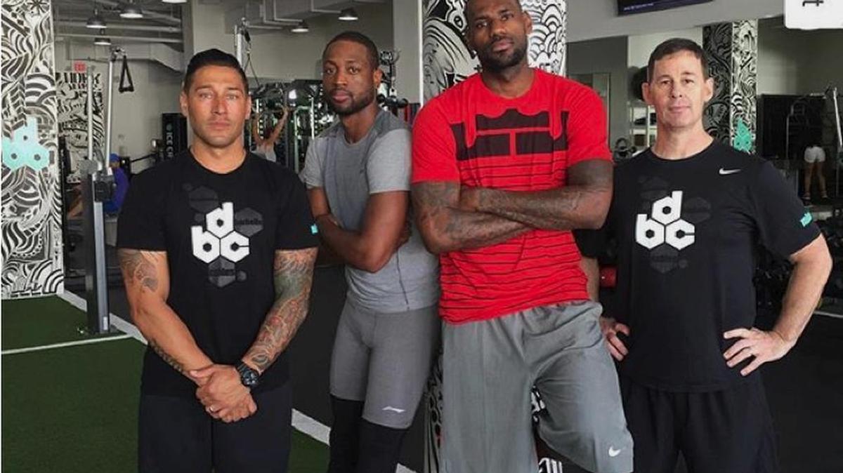 LeBron James y Dwyane Wade posan junto al entrenador David Alexander (izq.) en Miami.