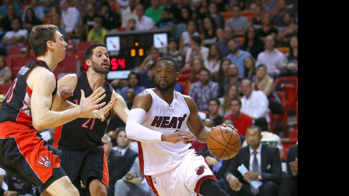 
Dwyane Wade (der.) conduce la pelota ante dos jugadores de Toronto, el 11 de abril del 2015.
