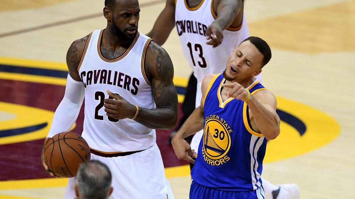 Stephen Curry (30), de los Warriors, increpa al árbitro, quien luego lo expulsó. LeBron James mira, el jueves.