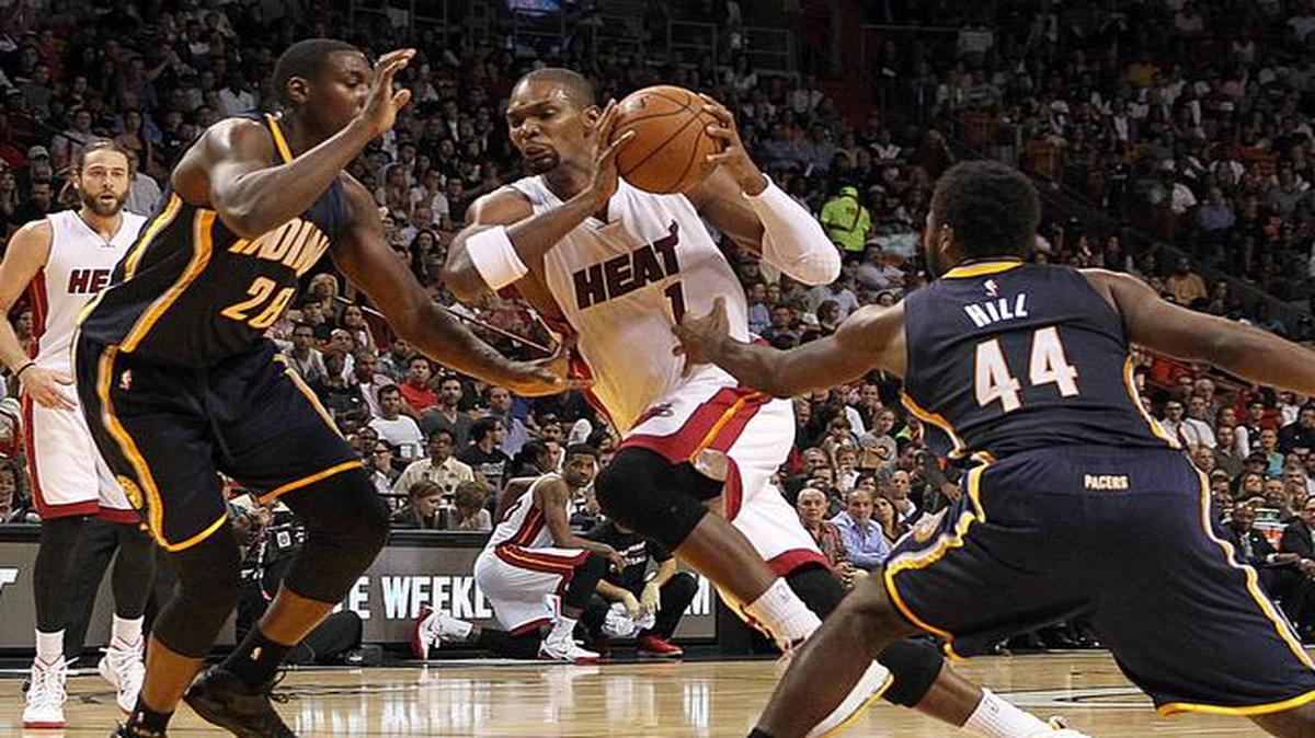 
Chris Bosh (centro) entra al aro ante la marca de Ian Mahinmi (izq.) y Solomon Hill, en el partido entre el Heat y los Pacers, el miércoles en Miami.


