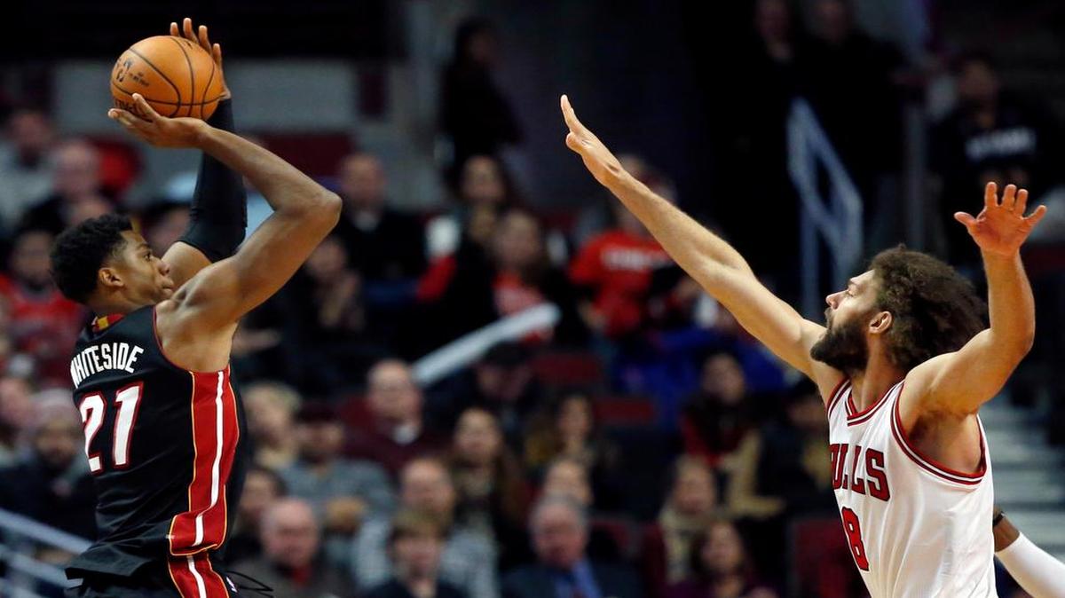 El centro del Heat Hassan Whiteside (izq.) tira al aro ante la marca del jugador de los Bulls Robin López, en el partido celebrado el sábado en Chicago.