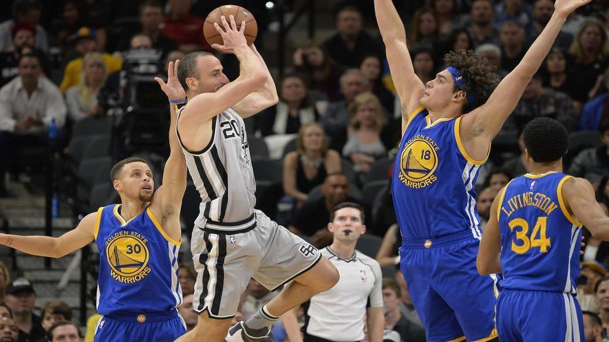 El jugador de los Spurs Manu Ginóbili (20) busca pasar el balón entre Anderson Varejao (18) y Stephen Curry, de los Warriors de Golden State, el 19 de marzo de 2016. 