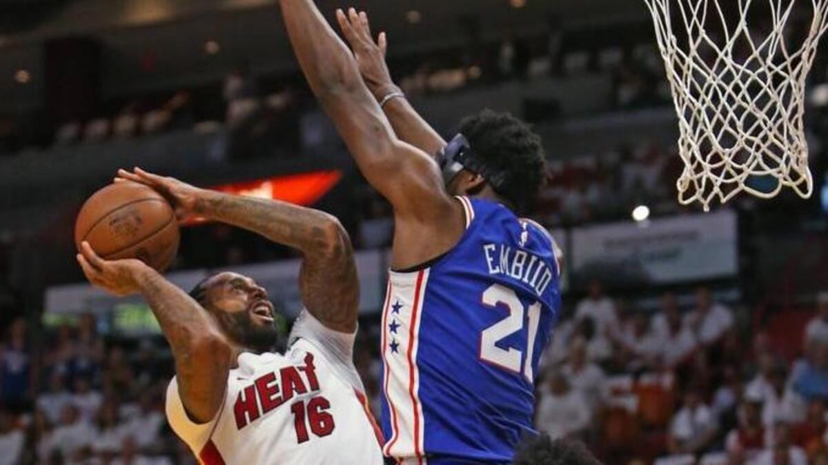 El jugador del Heat James Johnson tira al aro ante la marca de Joel Embiid, de Filadelfia, en el partido efectuado el 18 de abril de 2018 en Miami.
