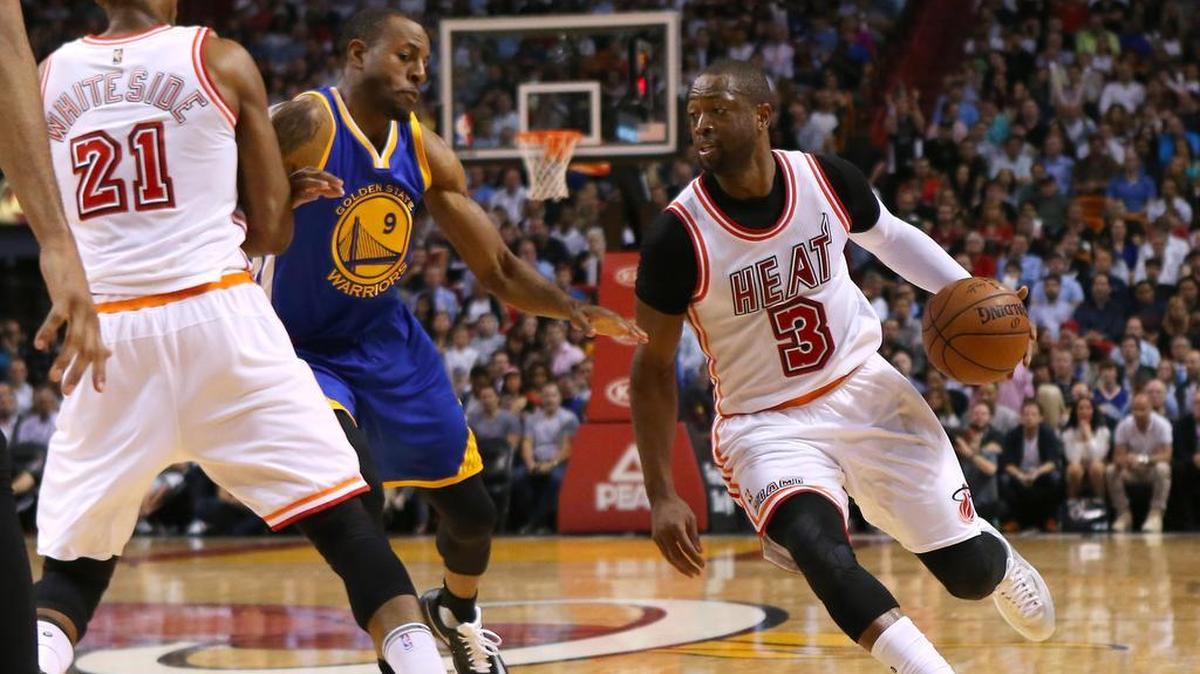 El escolta del Heat Dwyane Wade (der.) entra al aro ante la marca de Andre Iguodala, de los Warriors, en partido celebrado el 24 de febrero del 2016 en Miami.