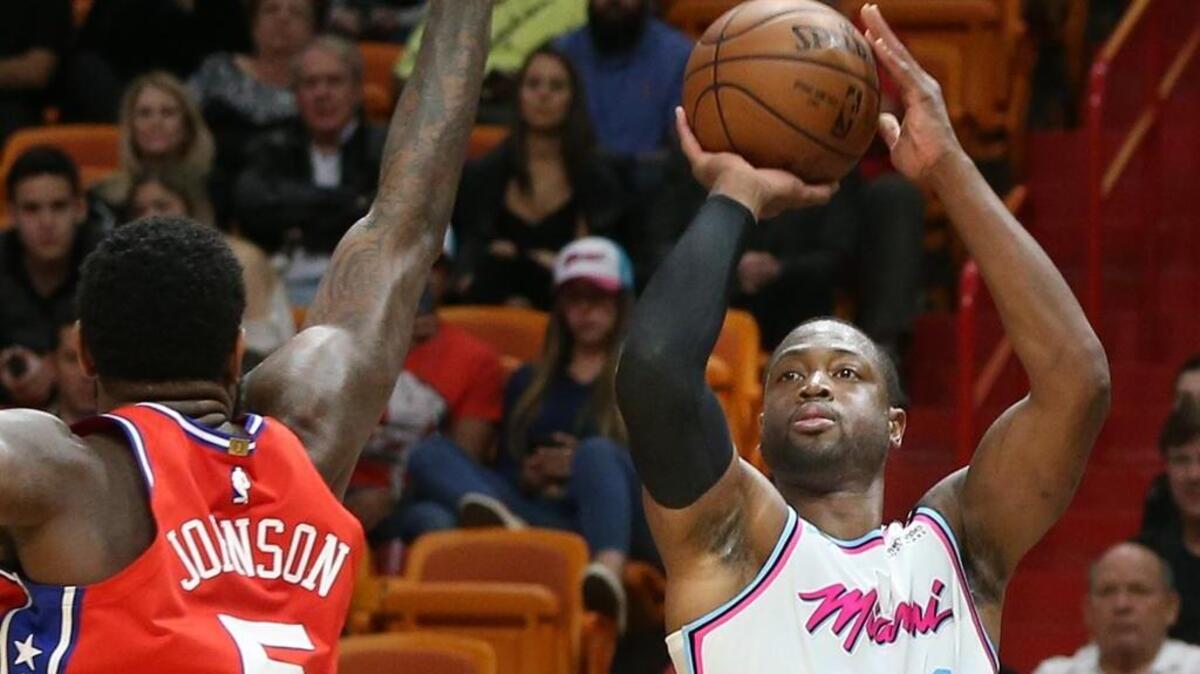 Dwyane Wade, del Heat (3), tira al aro ante la marca del jugador de los Sixers Amir Johnsonm, el 8 de marzo en el AmericanAirlines Arena.