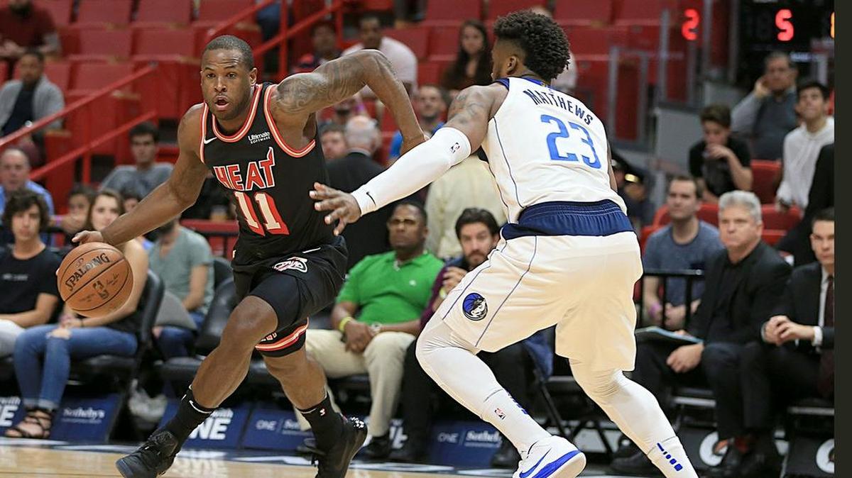 El jugador del Heat Dion Waiters (izq.) conduce la pelota ante la marca de Wesley Matthews, de los Mavericks, en el partido efectuado el 22 de diciembre de 2017 en Miami.