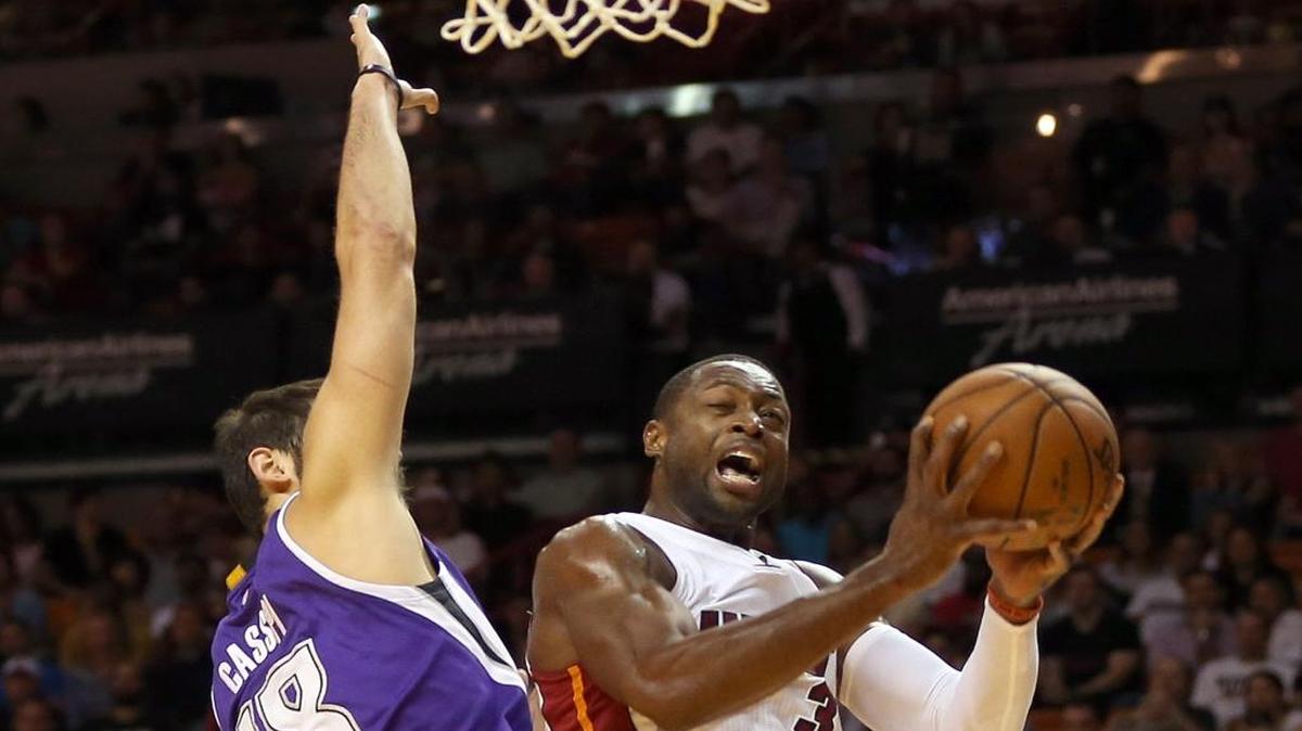 Dwyane Wade, del Heat, enfrenta la marcación de Omri Casspi (18), de los Kings, el jueves.