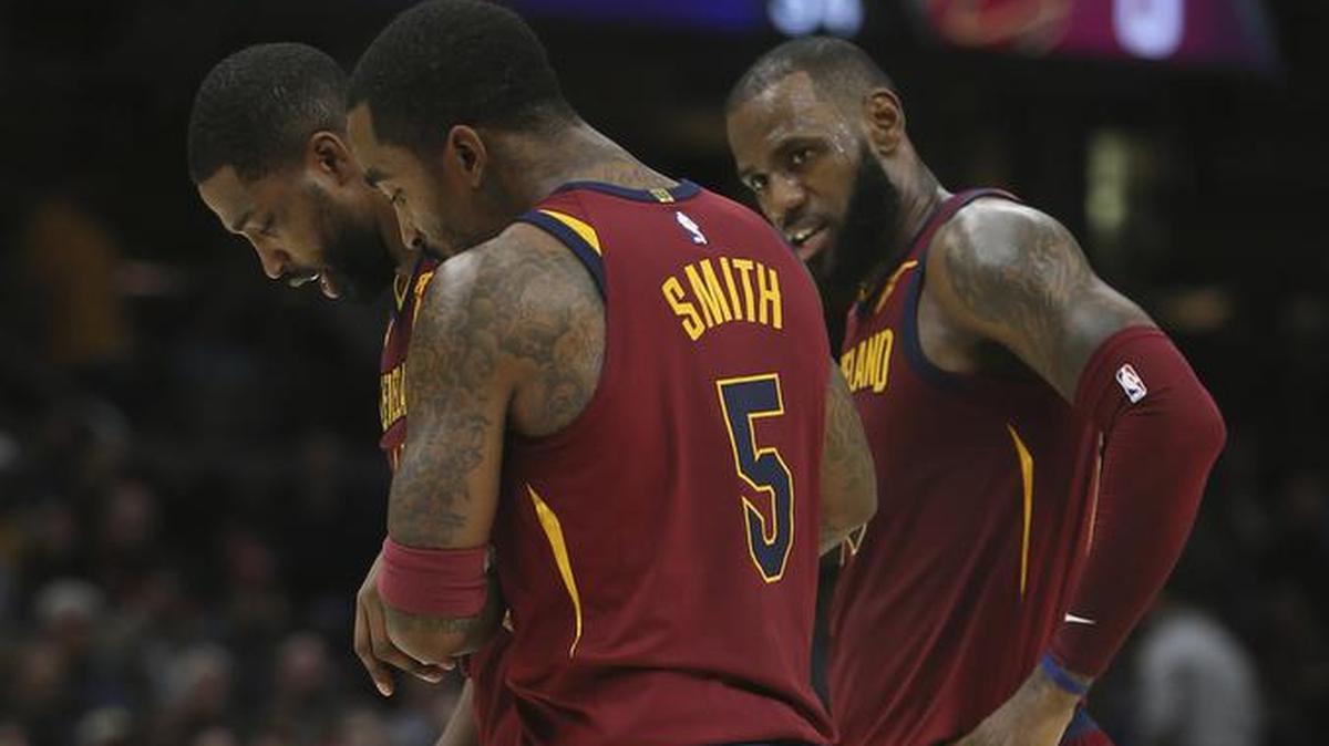 J.R. Smith (5) y LeBron James (der.), de los Cavaliers, acompaña a Tristan Thompson a salir de la cancha este miercoles en el Quicken Loans Arena de Cleveland.