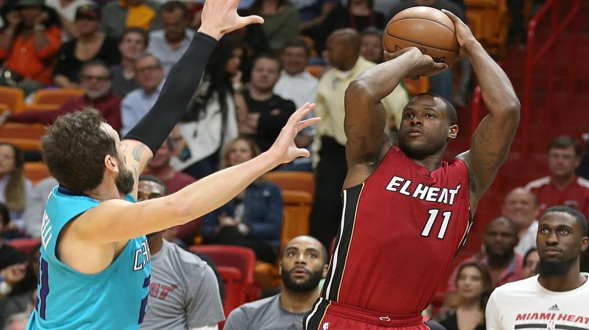 Dion Waiters, del Heat, lanza sobre Marco Belinelli, de los Hornets, en el AAA en Miami, el miércoles pasado.