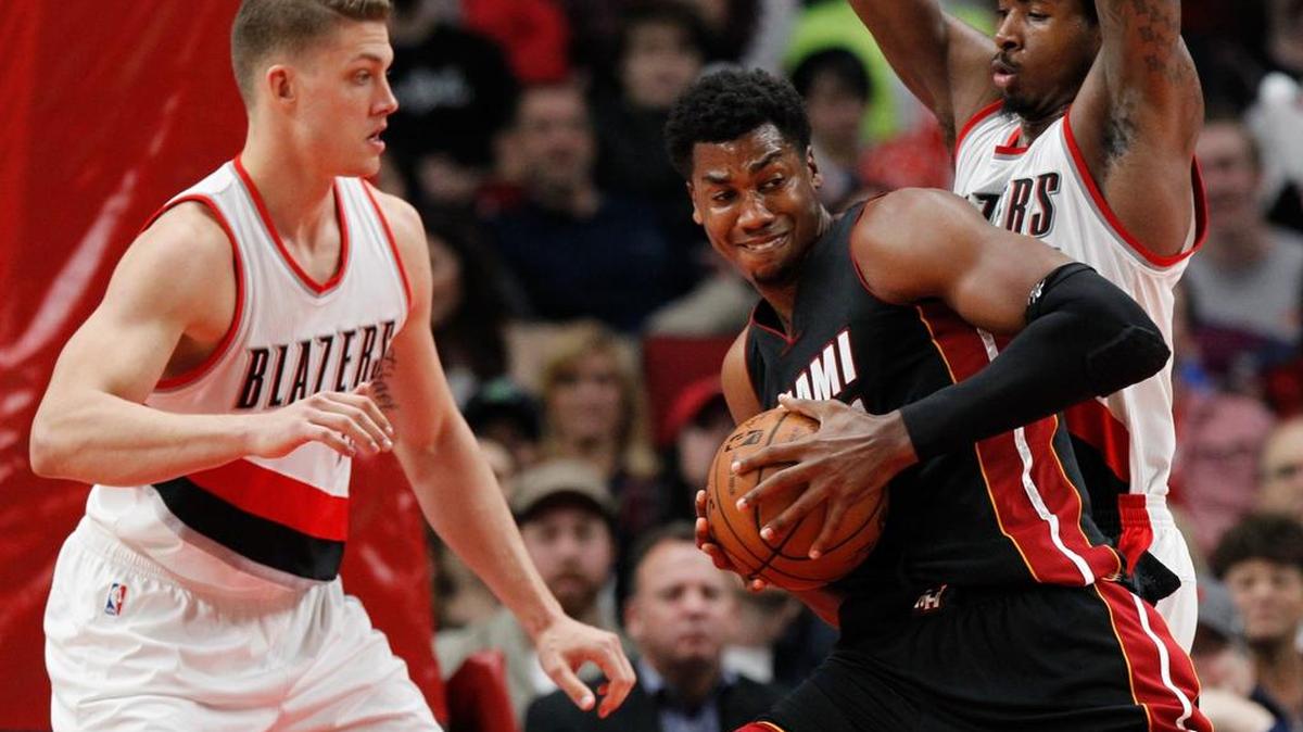 Hassan Whiteside, del Heat, maniobra contra Meyers Leonard (izq.) y Ed Davis, de Portland, el sábado.