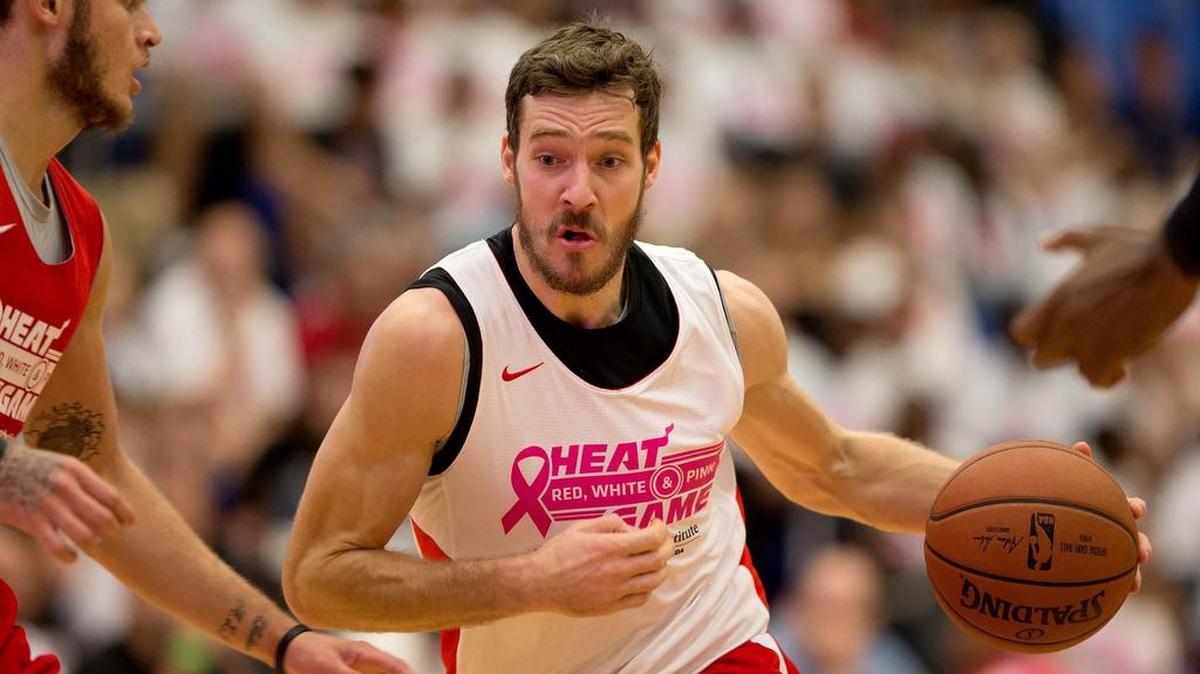 El armador del Heat Goran Dragic (der.) entra al aro ante la marca de Tyler Johnson el sábado en (7) el juego simulado entre Rojo, Blanco y Rosa en FAU.
