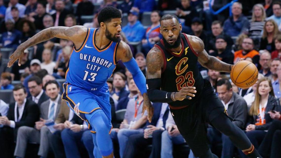El astro de los Cavaliers LeBron James (23) baja el balón ante la marca de Paul George del Thunder, en el triunfo de este martes en Oklahoma City.