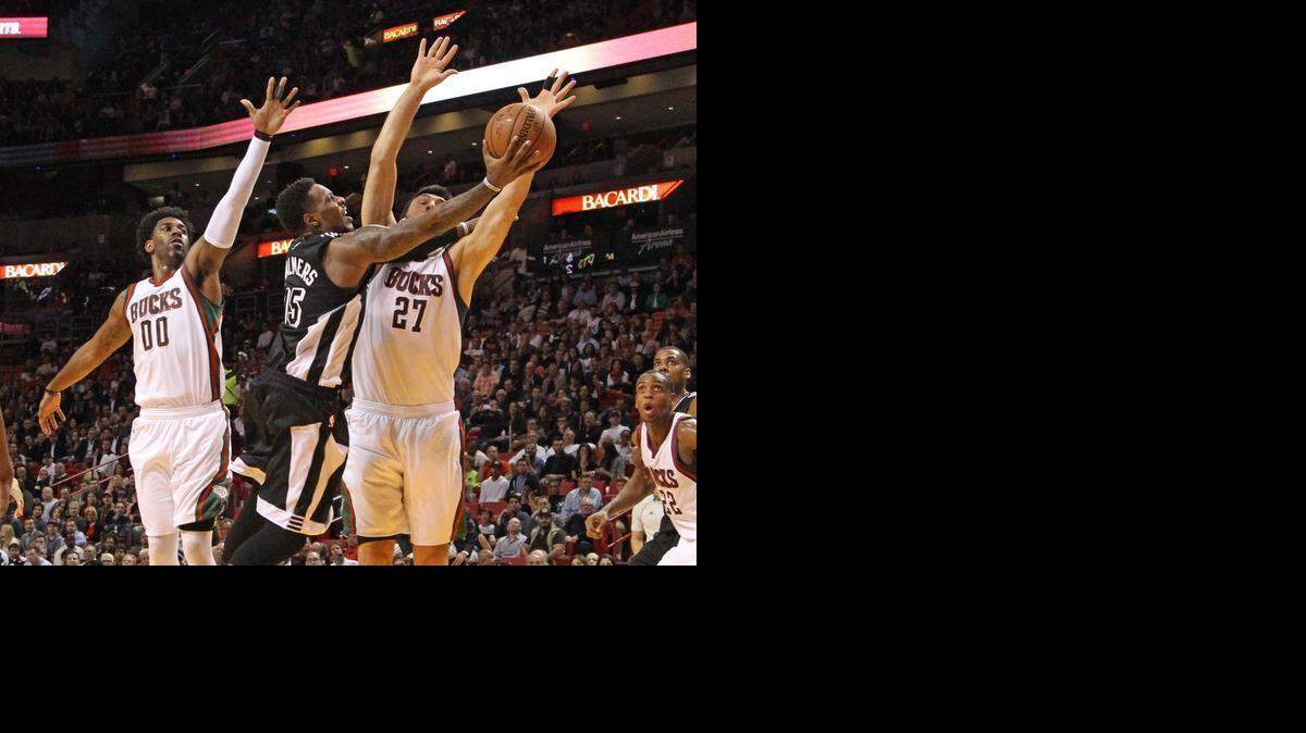 
Mario Chalmers (centro) trata de lograr la canasta para el Heat en el partido contra los Bucks, el martes en Miami.


