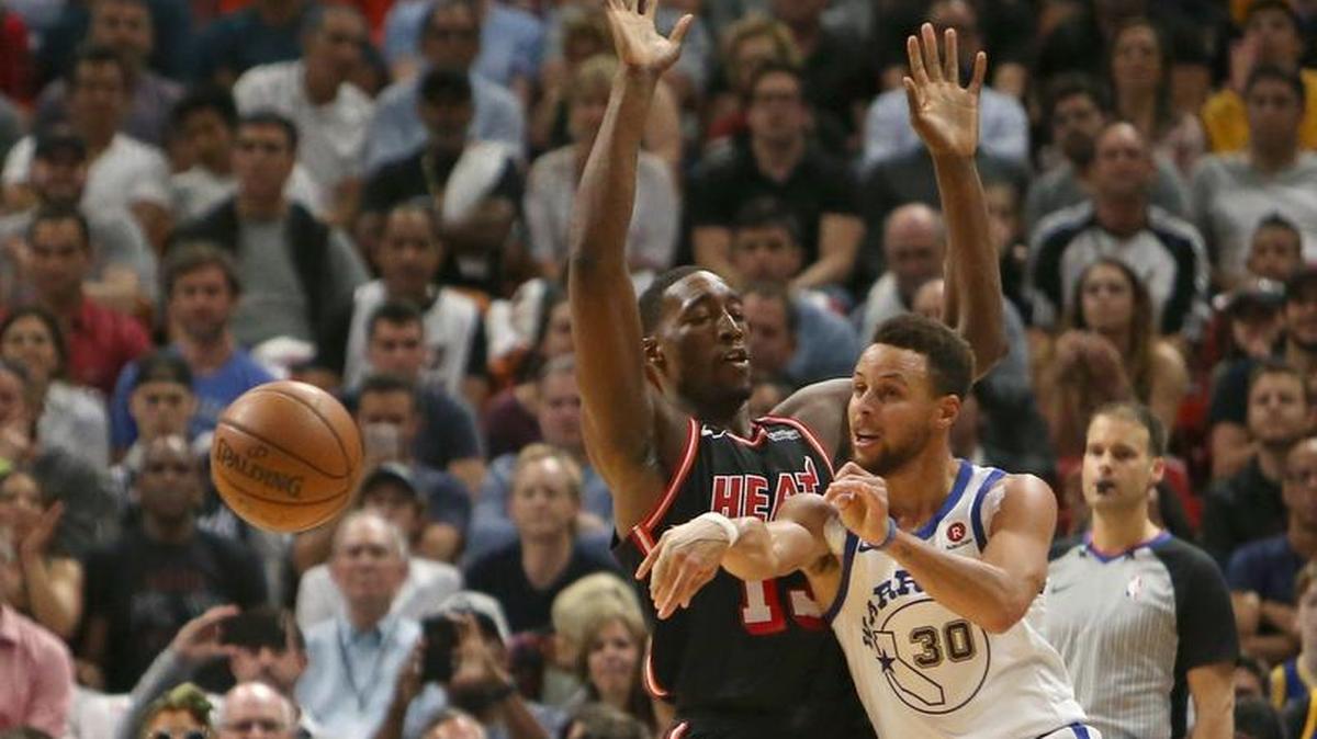 El armador de los Warriors Stephen Curry pasa la pelota ante la defensa de Bam Adebayo, del Heat, en el partido celebrado el 3 de diciembre en Miami.
