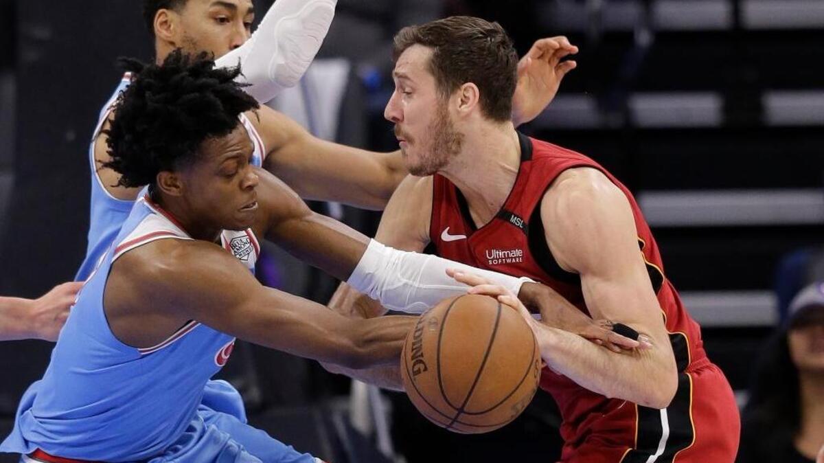 El jugador de los Kings De'Aaron Fox (izq.) pugna por el balón con el armador del Heat Goran Dragic, el 14 de diciembre en Sacramento.