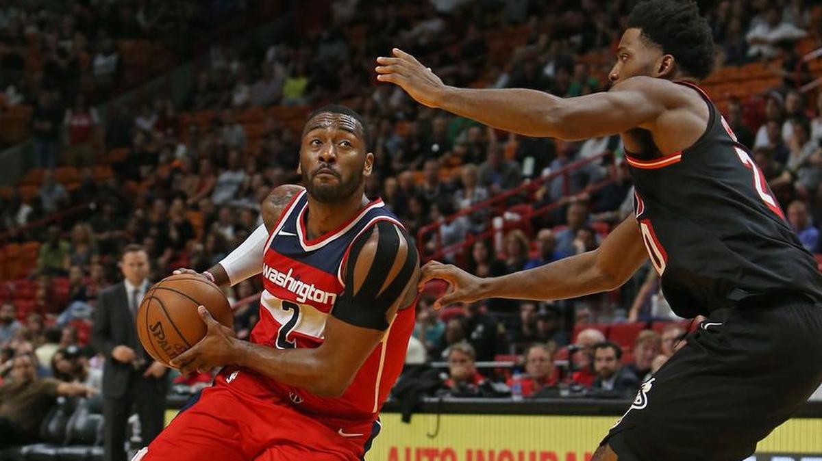 Justise Winslow, delantero del Heat, trata de detener al armador de los Wizards John Wall (izq.) el 15 de noviembre en el American Airlines Arena.