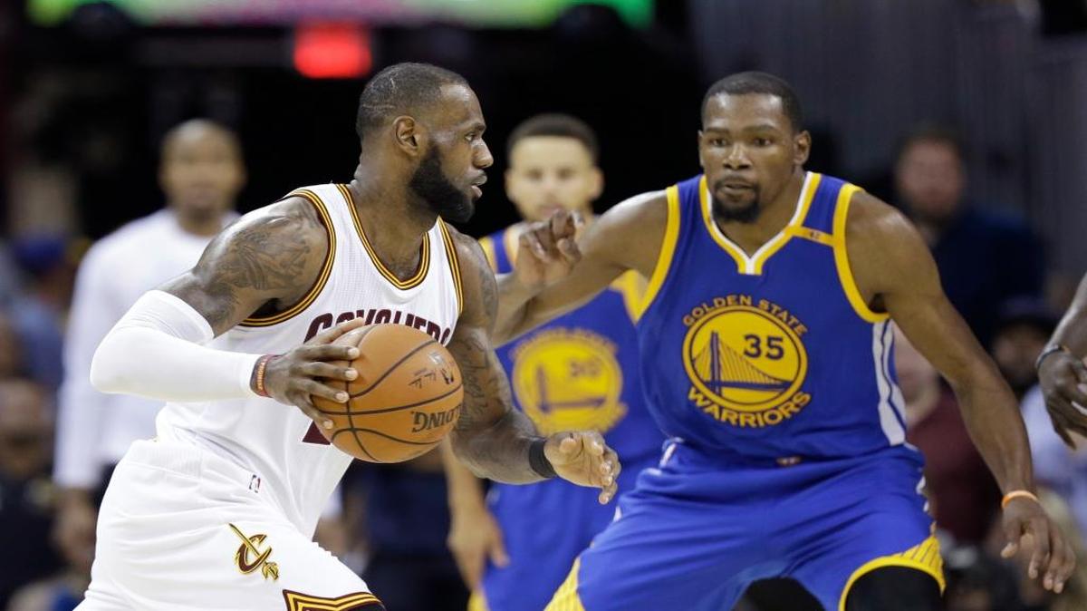 El jugador de los Warriors Kevin Durant (der.) marca a LeBron James, de los Cavaliers, en el Juego 4 de las Finales de la NBA, el viernes 9 de junio del 2017 en Cleveland.