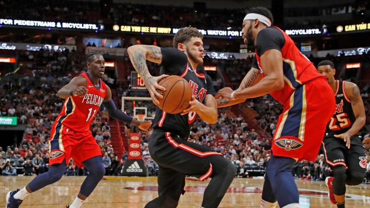 El defensa del Heat Tyler Johnson (8) trata de penetrar al aro ante la marca del jugador de los Pelicans, este sábado en el American Airlines Arena.