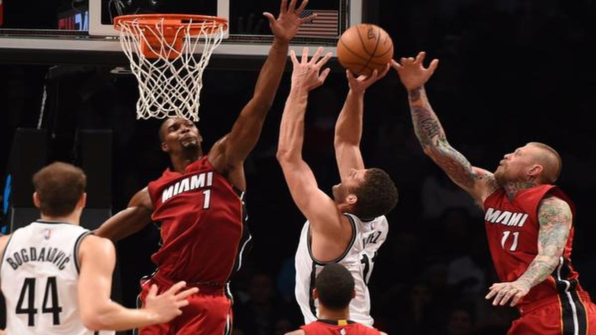 
Los jugadores del Heat Chris Bosh (#1) y Chris Andersen (der.) tratan de bloquear el tiro de Brook López, de los Nets, en el partido del lunes en Nueva York.


