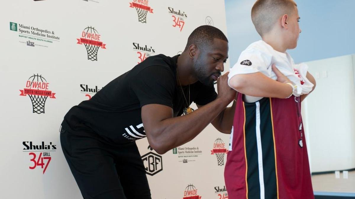 Dwyane Wade estampa su autógrafo en el niño de 12 años Nathan Mouradian, en su Youth Camp, el sábado.