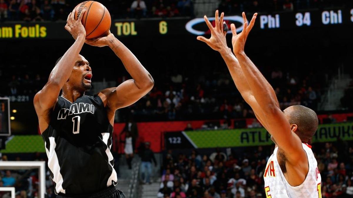 Chris Bosh (izq.) tira al aro ante la marca de Al Horford, en el partido entre el Heat y los Hawks, el lunes 14 de diciembre del 2015.