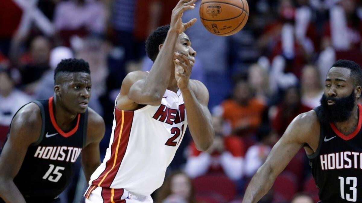 El centro del Heat Hassan Whiteside (21) pasa el balón entre los jugadores de los Rockets Clint Capela (15) y James Harden (13), el lunes en Houston.