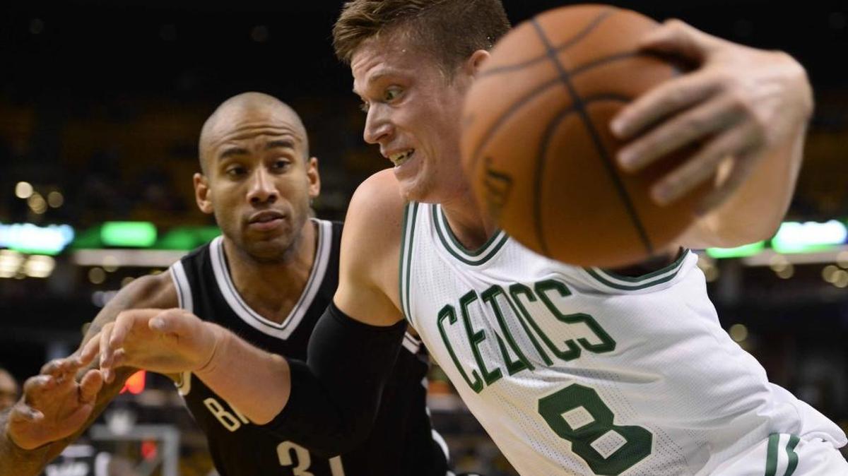 Jonas Jerebko (der.) de Boston Celtics disputa el balón contra Dahntay Jones de los Brooklyn Nets, el lunes 19 de octubre durante un juego de pretemporada de la NBA en el TD Garden de Boston, Massachusetts.