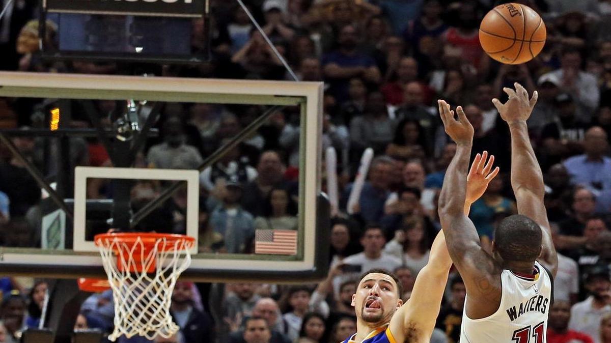 El momento de oro. Con 0.6 segundos para terminar el partido, Dion Waiters (11) lanza el triple de la victoria sobre Klay Thompson, de los Warriors, para sellar el 105-102 del Heat en inolvidable actuación en el AmericanAirlines Arena, en Miami, la noche del lunes 23 de enero del 2017.