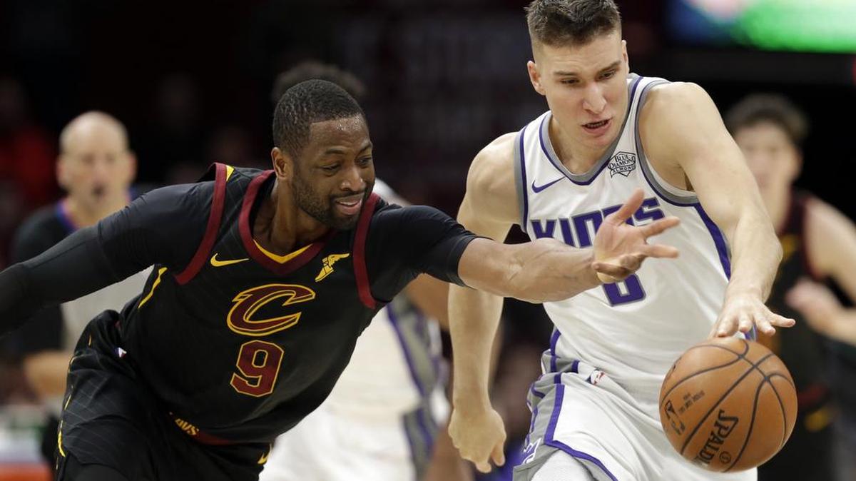 Dwyane Wade, de los Cavaliers (9), y el jugador serbio de los Kings, Bogdan Bogdanovic (8), batallan por un balón suelto el 6 de diciembre en Cleveland.
