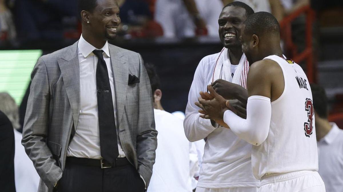 CHRIS BOSH conversa con Luol Deng (c) y Dwyane Wade (3) el 17 de abril del 2916 en Charlotte.