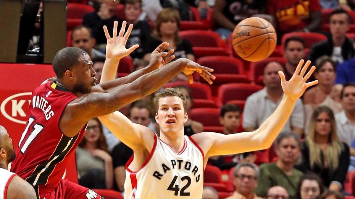 Dion Waiters, del Heat, pasa la bola sobre Jakob Poeltl, de los Raptors, en el AmericanAirlines Arena en Miami, la noche del sábado 11 de marzo del 2017.